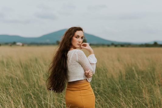 Woman with long brown hair standing on a field