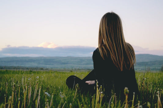 Woman with long hair sitting in the grass