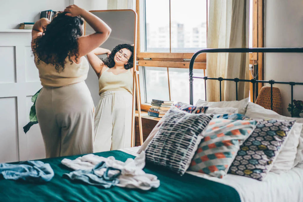 Woman with curly hair looking in the mirror