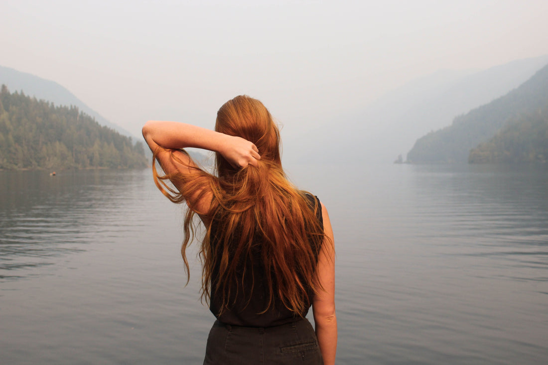 Women with red hair looking at the sea