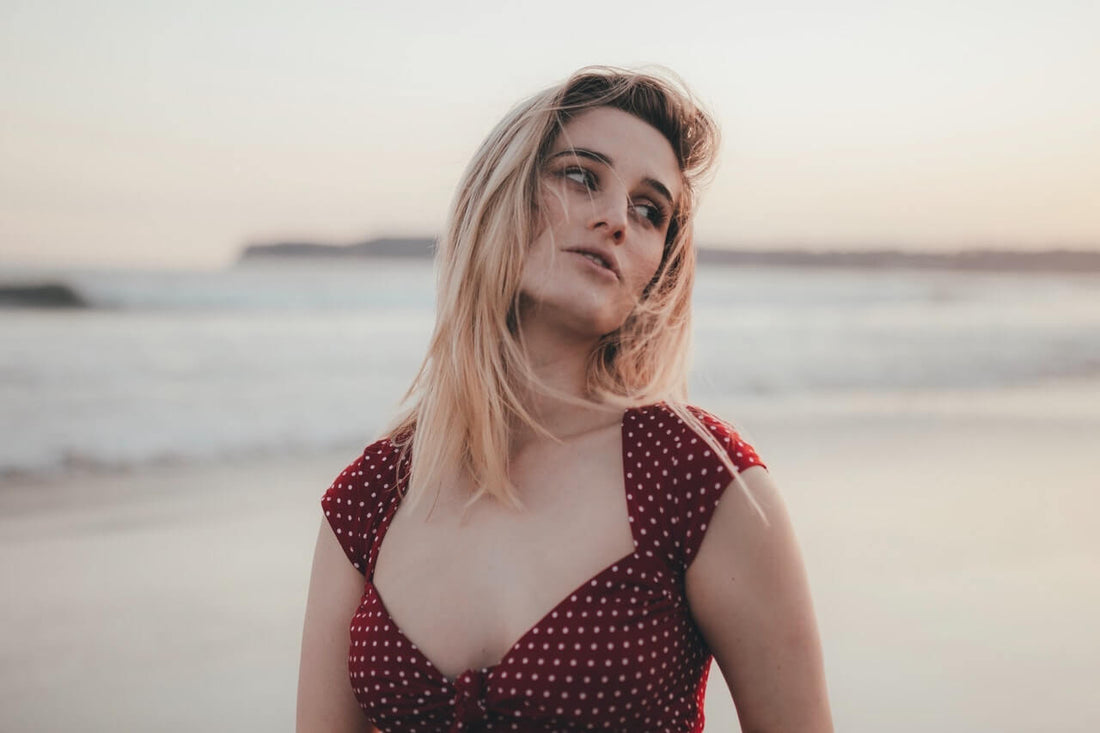 Blonde woman on the beach in a red dress