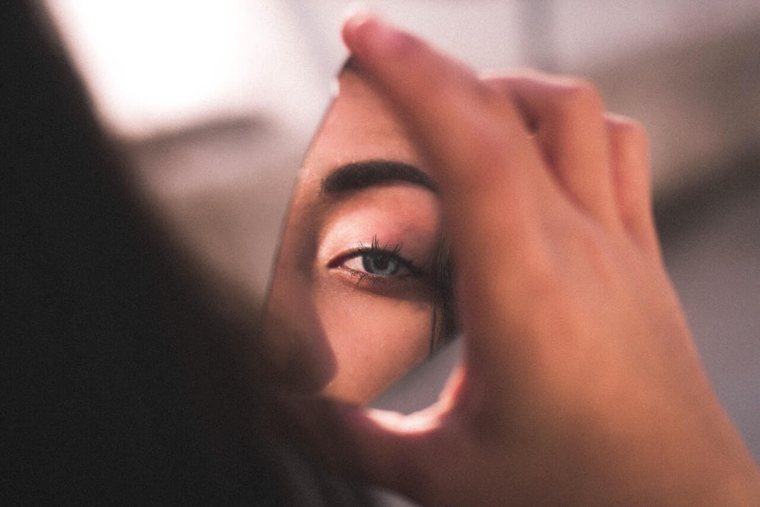 Woman looking at her reflection in a mirror